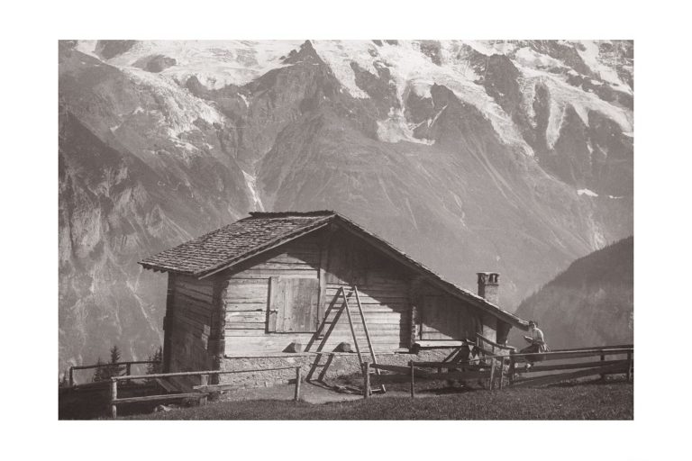 Photo d'époque Montagne n°112 - lecture près d'un chalet de montagne avec vue sur les sommets enneigés